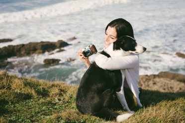 An owner hugging her Border Collie while traveling